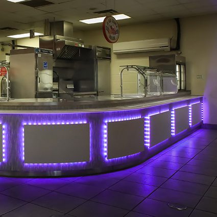 Custom restaurant serving line with stainless steel equipment and illuminated front panels