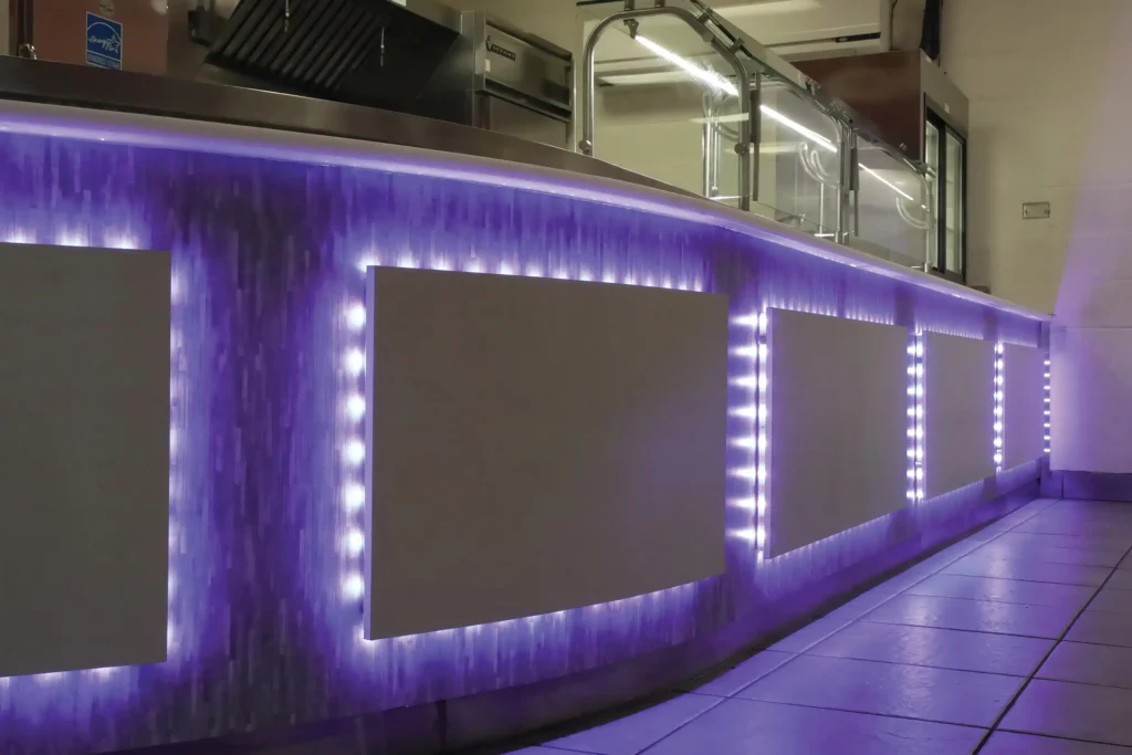 Custom curved serving line with glass food guards and illuminated panels