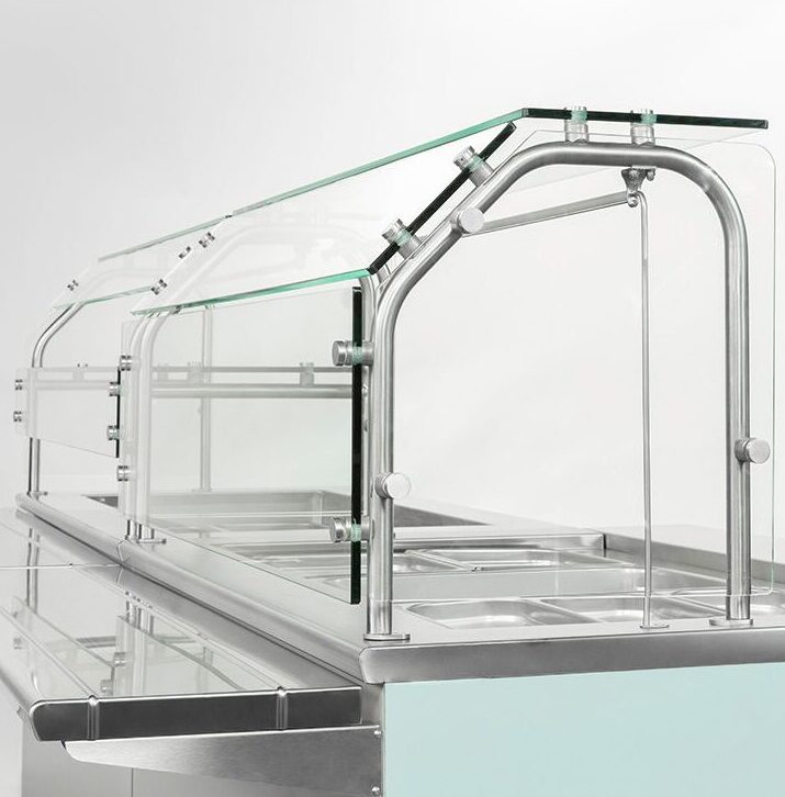 Glass food guard with stainless steel supports on a serving line
