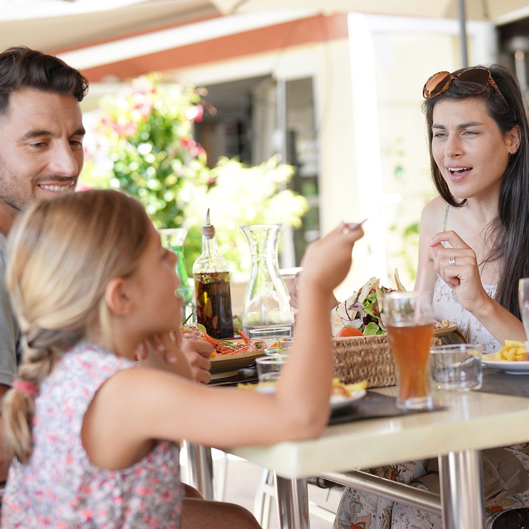 Family enjoying food and drinks at an outdoor dining table