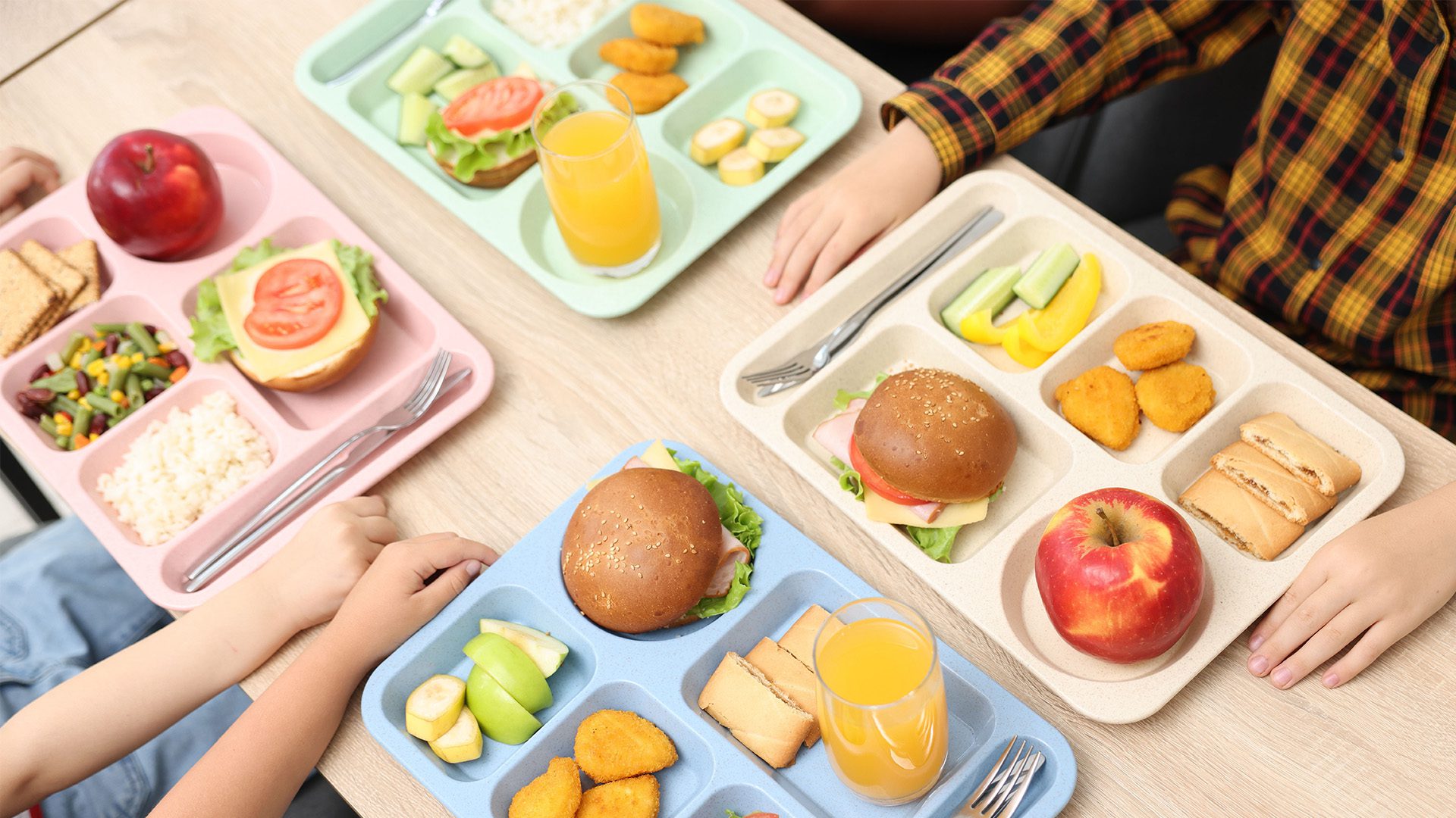 Students eating school lunches at a cafeteria table