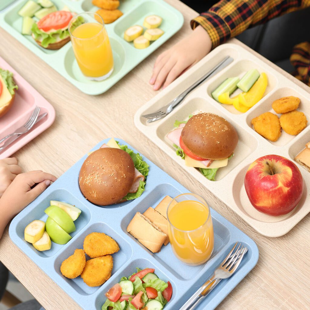 Students eating school lunches at a cafeteria table