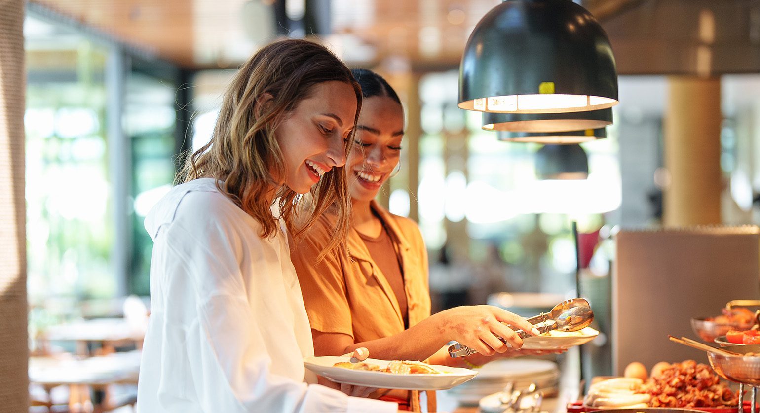 Guests getting food from a restaurant buffet